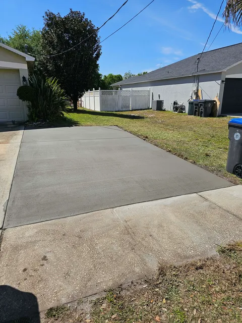 Concrete driveway extension beside a garage
